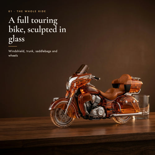 Glass decanter shaped as a full touring motorcycle on a dark walnut bar top