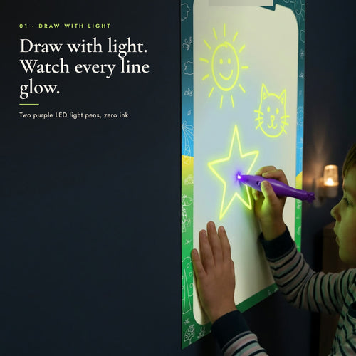 Child's hand drawing a glowing star on the glow canvas with a purple LED light pen